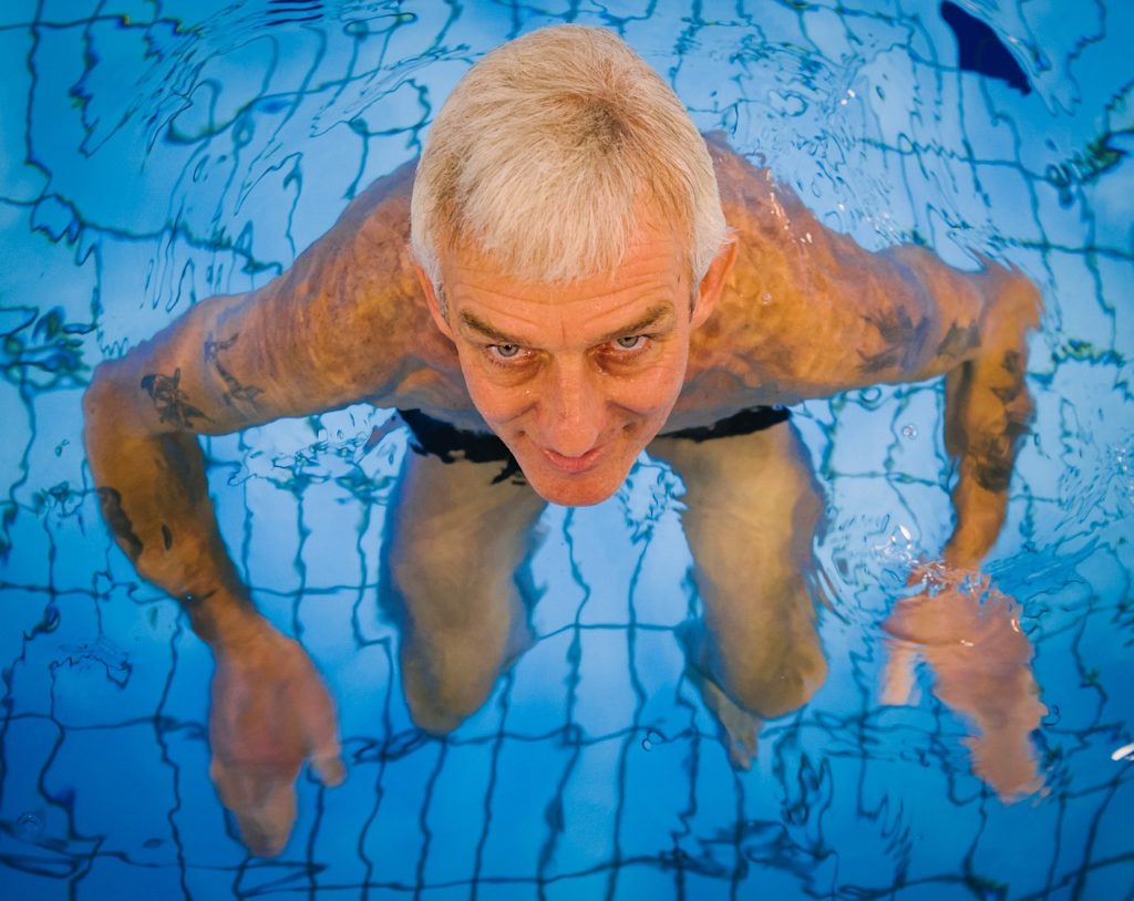 Old man squatting in a swimming pool