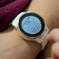 The Garmin watch is wrapped around the arm in white and the reset function and other settings appear on the screen