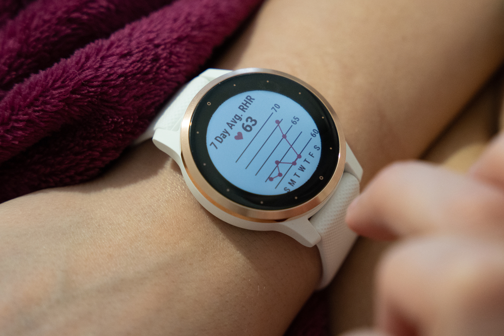 The Garmin watch is wrapped around the arm in white and the reset function and other settings appear on the screen