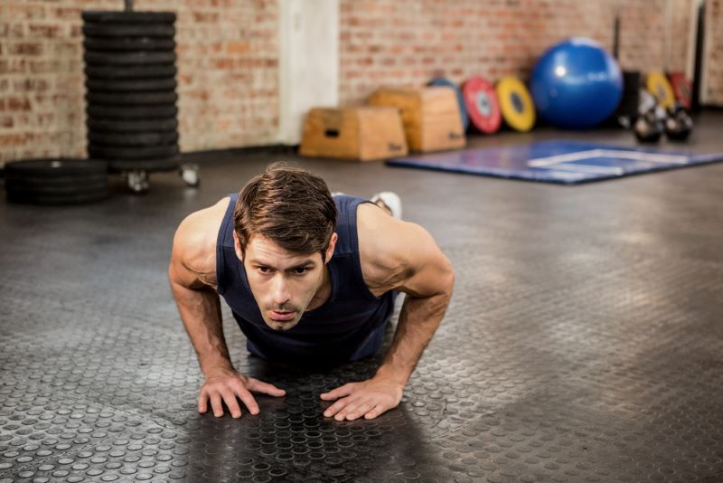 Man doing a narrow-grip push-up in a gym