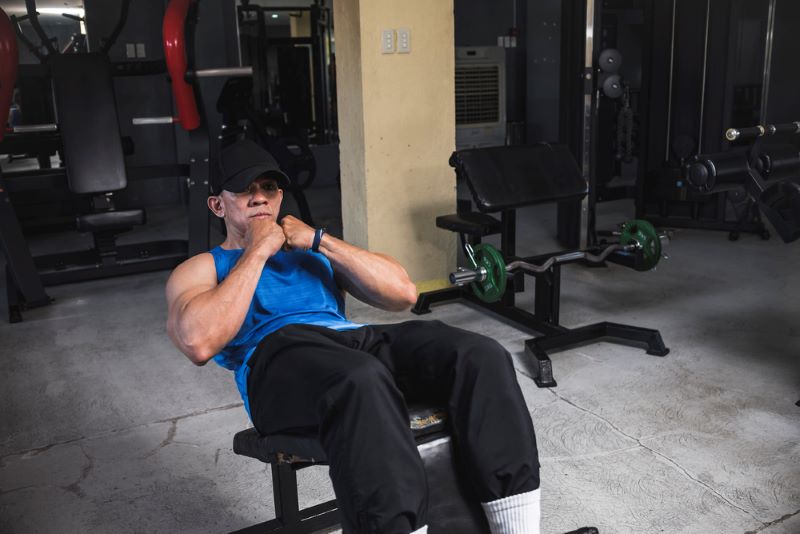 man doing decline sit-ups in a gym
