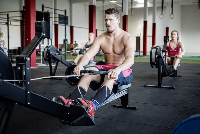 shirtless man on rowing machine