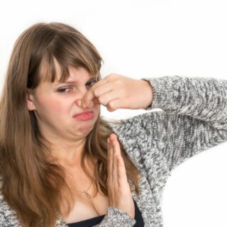 woman holding her nose after a smelly fart